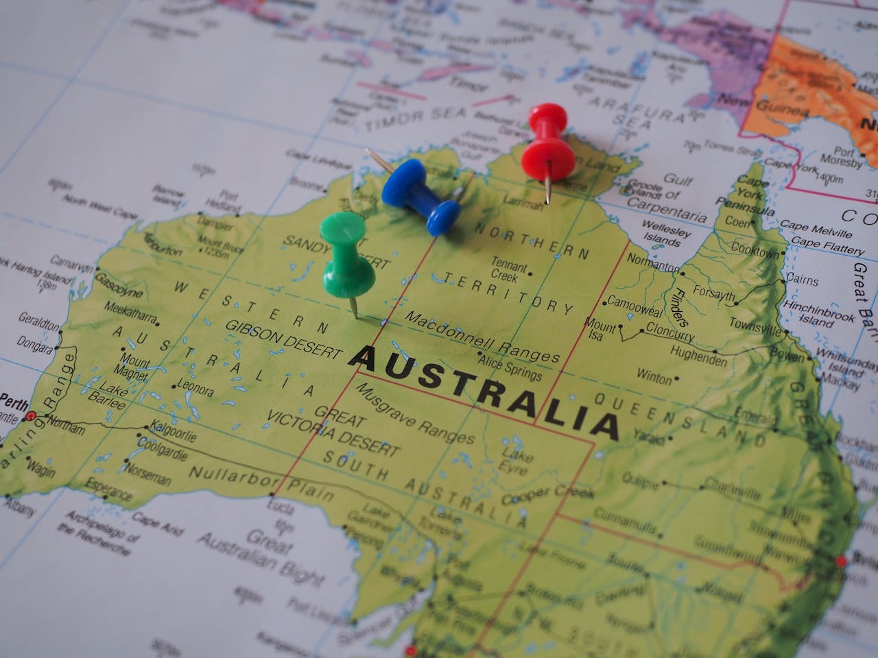 Close-up of a map of Australia featuring colorful pushpins marking locations.
